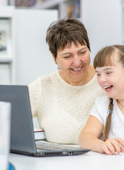 A,Girl,With,Down,Syndrome,Is,Uses,A,Laptop,With